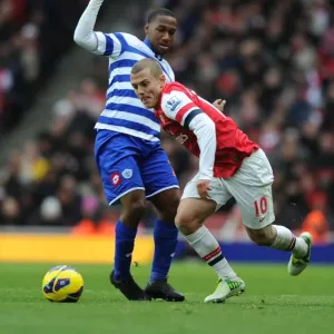 Arsenal's Jack Wilshere Outmaneuvers QPR's Junior Hoilett during the 2012-13 Premier League Match