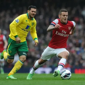 Arsenal's Jack Wilshere Surges Past Norwich's Bradley Johnson in 2012-13 Premier League Clash Arsenal's Jack Wilshere Surges Past Norwich's Bradley Johnson in 2012-13 Premier League Clash