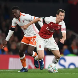 Arsenal's Lichtsteiner Clashes with Blackpool's Bola in Carabao Cup Showdown