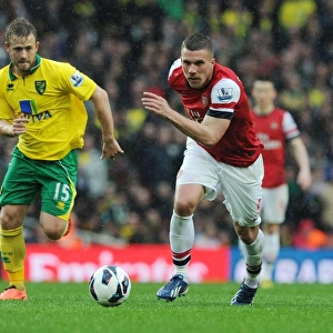 Arsenal's Lukas Podolski Outmaneuvers Norwich's David Fox in 2012-13 Premier League Clash