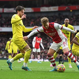Arsenal's Martin Odegaard Clashes with Brentford's Mathias Jensen and Rico Henry during the Premier League Match