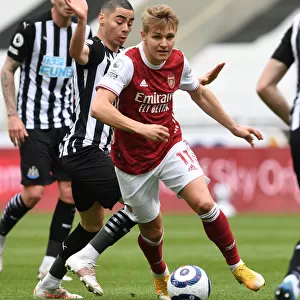 Arsenal's Martin Odegaard Outmaneuvers Newcastle's Miguel Almiron in Empty St. James Park