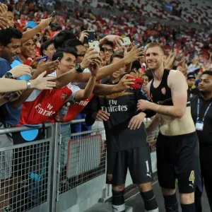 Arsenal's Per Mertesacker Celebrates with Fans after Arsenal's Victory over Singapore XI in Singapore, 2015