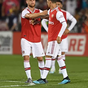 Arsenal's Mesut Ozil Receives Captain's Armband from Shkodran Mustafi during Colorado Rapids Match, 2019