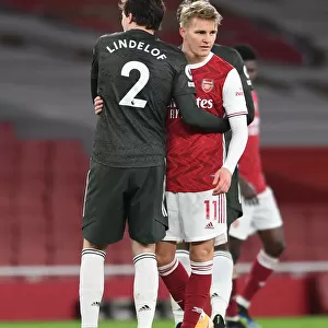 Arsenal's Odegaard Embraces Lindelof Amid Empty Emirates Stadium - Arsenal vs Manchester United, 2021