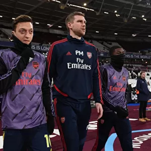 Arsenal's Ozil and Mertesacker Lead Team Out Against West Ham in Premier League Clash