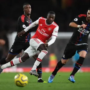 Arsenal's Pepe Faces Pressure from Palace's Zaha and Milivojevic during Premier League Clash