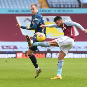 Arsenal's Rob Holding Blocks Aston Villa's Mahmoud Trezeguet: A Premier League Clash Amidst COVID-19 Restrictions