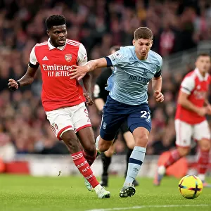 Arsenal's Thomas Partey Fends Off Pressure from Brentford's Vitaly Roerslev During Premier League Clash