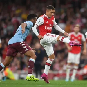 Arsenal's Torreira Fends Off Aston Villa's Taylor Amidst Premier League Battle