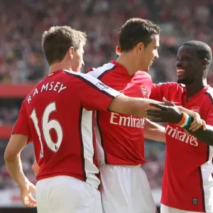 Arsenal's Unstoppable Force: Ramsey, van Persie, and Eboue Celebrate a 4-1 Victory Over Portsmouth