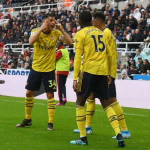 Arsenal's Xhaka, Maitland-Niles, and Aubameyang in Action against Newcastle United (2019-20) Arsenal's Xhaka, Maitland-Niles, and Aubameyang in Action against Newcastle United (2019-20)