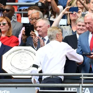 Arsene Wenger the Arsenal Manager is handed his medal by Bob Wilson the former Arsenal