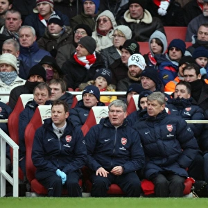 Arsene Wenger the Arsenal Manager sits in the dug out with Pat Rice (Assistant)