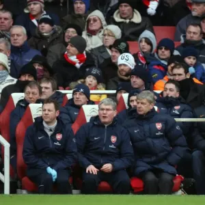 Arsene Wenger the Arsenal Manager sits in the dug out with Pat Rice (Assistant)