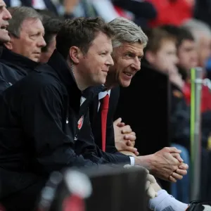 Arsene Wenger and Colin Lewin Share a Light-Hearted Moment during Arsenal's Pre-Season Match against Anderlecht (2012)