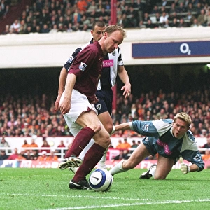 Dennis Bergkamp takes the ball away from Neil Clement and Tomasz Kuszczak
