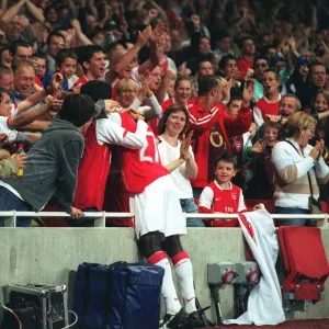 Emmanuel Eboue celebrates with the fans after Thierry Henrys goal for Arsenal