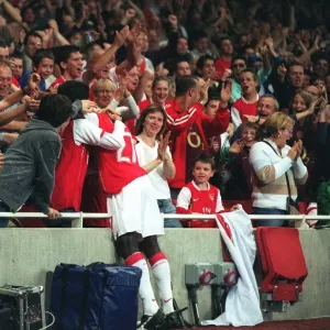 Emmanuel Eboue celebrates with the fans after Thierry Henrys goal for Arsenal
