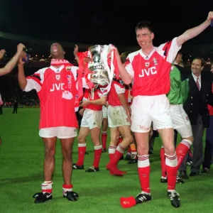 Ian Wright and Andy Linighan, the scorer of the winning goal, celebrate with the FA Cup Trophy after