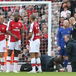 Injured Arsenal goalkeeper Manuel Almunia is treated