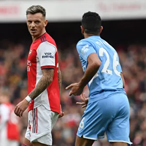 Intense Rivalry: Ben White and Riyad Mahrez Lock Eyes in the Arsenal vs. Manchester City Clash