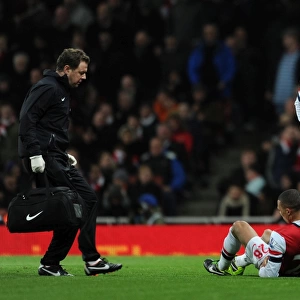 Kieran Gibbs (Arsenal) lies injured on the floor as Physio Colon Lewin races to help him