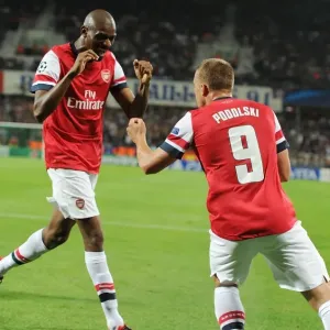 Lukas Podolski and Abou Diaby Celebrate Arsenal's First Goal Against Montpellier (2012-13) Lukas Podolski and Abou Diaby Celebrate Arsenal's First Goal Against Montpellier (2012-13)