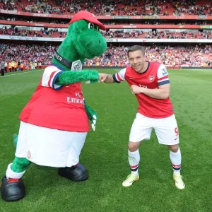 Lukas Podolski with Gunnersaurus: Arsenal vs. West Bromwich Albion, Premier League 2013-14 Lukas Podolski with Gunnersaurus: Arsenal vs. West Bromwich Albion, Premier League 2013-14