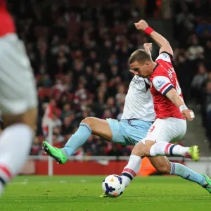 Lukas Podolski scores his and Arsenals 1st goal under pressure from Winston Reid (West Ham)