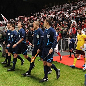 The match officials lead out the teams lead by Arsenal captain Cesc Fabregas