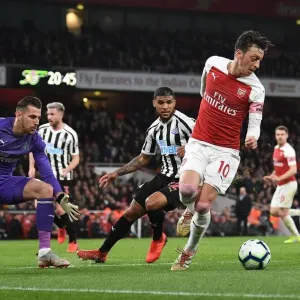 Mesut Ozil Faces Intense Pressure from Newcastle's DeAndre Yedlin and Martin Dubravka during Arsenal vs Newcastle Premier League Match Mesut Ozil Faces Intense Pressure from Newcastle's DeAndre Yedlin and Martin Dubravka during Arsenal vs Newcastle Premier League Match