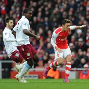 Mesut Özil erzielt Arsenal sein zweites Tor unter Druck von Jores Okore und Carles Gil (Villen) Mesut Özil erzielt Arsenal sein zweites Tor unter Druck von Jores Okore und Carles Gil (Villen)