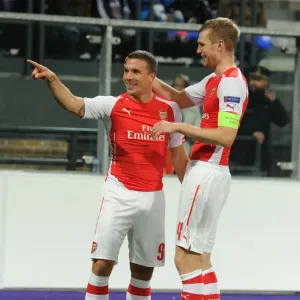 Podolski and Mertesacker Celebrate Arsenal's Second Goal Against Anderlecht in 2014-15 Champions League