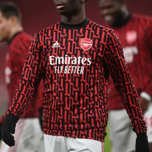 Print of Bukayo Saka warming up at empty Emirates Stadium
