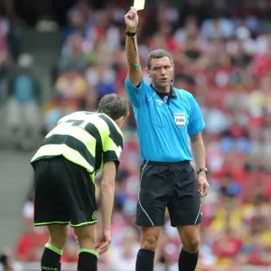 Referee Andre marriner shows a yellow card to Charlie Mulgrew (Celtic)