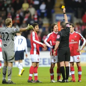 Referee Phil Dowd shows the yellow card to Arsenals Tomas Rosicky