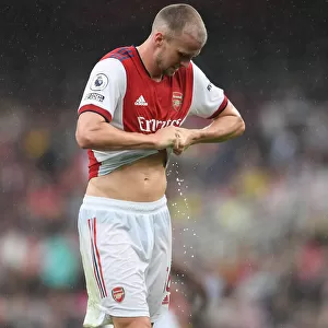 Sweat and Determination: Arsenal's Rob Holding Rings Out Shirt Amidst Intense Arsenal v Chelsea Rivalry (Premier League 2021-22)
