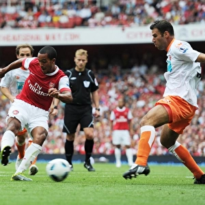 Theo Walcott shoots past Blackpool defender Dekel Keinan to score the 3rd Arsenal goal