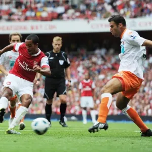 Theo Walcott shoots past Blackpool defender Dekel Keinan to score the 3rd Arsenal goal
