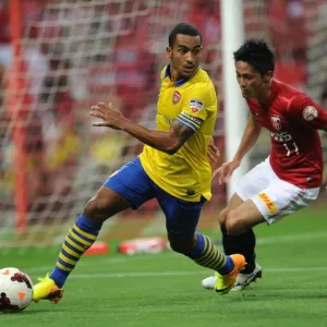 Theo Walcott vs. Kunimitsu Sekiguchi: A Battle for Ball Possession in Arsenal's 2013-14 Pre-Season Clash Theo Walcott vs. Kunimitsu Sekiguchi: A Battle for Ball Possession in Arsenal's 2013-14 Pre-Season Clash