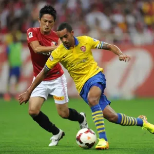 Theo Walcott vs. Kunimitsu Sekiguchi: A Battle for Ball Possession in Arsenal's Pre-Season Clash (2013) Theo Walcott vs. Kunimitsu Sekiguchi: A Battle for Ball Possession in Arsenal's Pre-Season Clash (2013)