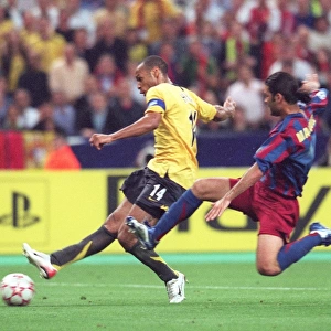 Thierry Henry (Arsenal) shoots under pressure from Rafael Marquez (Barcelona)