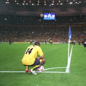 Thierry Henry (Arsenal) waits to take a corner watched by a cameraman