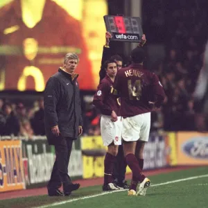 Thierry Henry walks over to talk to Arsene Wenger the Arsenal manager as he brings on Robin van Pers