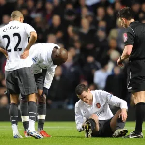 Thomas Vermaelen sits injuryed on the pitch as Gael Clichy and William Gallas
