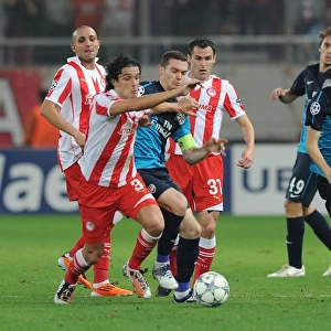 Thomas Vermaelen vs. Yossi Benayoun and Franck Modest: Intense Clash Between Olympiacos and Arsenal FC in the UEFA Champions League