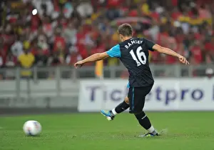 Aaron Ramsey shoots past Malaysia goalkeeper Khairul Che Mat to score the 1st Arsenal goal