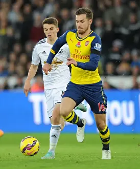 Swansea V Arsenal 2014-15 Prints: Aaron Ramsey's Sneaky Moves: Outsmarting Tom Carroll in Swansea Derby