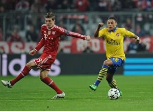Images Dated 11th March 2014: Alex Oxlade-Chamberlain vs Toni Kroos: Battle in the UEFA Champions League between Bayern Munich